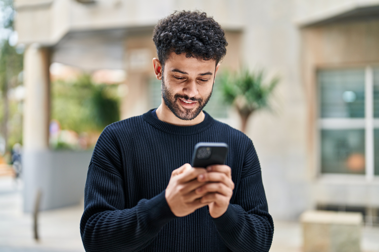 man in blue shirt looking at phone