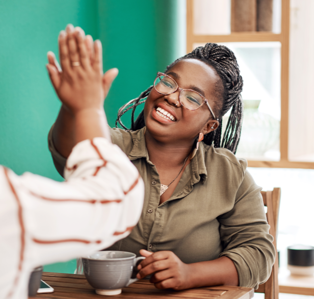 woman in green shirt high-fiving someone